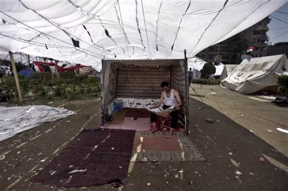 An Egyptian demonstrator reads the newspaper July 9 as he sits in a tent during a second day of protests in Tahrir Square in Cairo, Egypt. What appeared an unstoppable groundswell for change across the Middle East earlier this year, has splintered into scattered and indecisive conflicts that have left thousands dead and Western policy makers juggling roles.